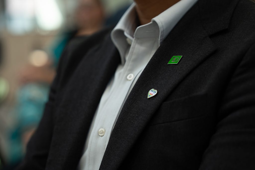 A person with dyed green bangs laughs outside.