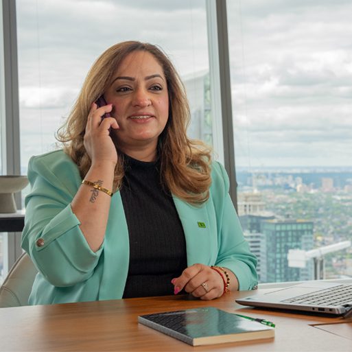 A colleague smiles while seated at a table in a conference room.