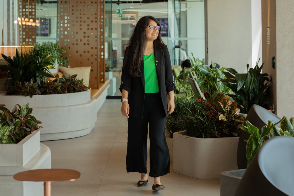 A colleague holds their smartphone while seated in an office.