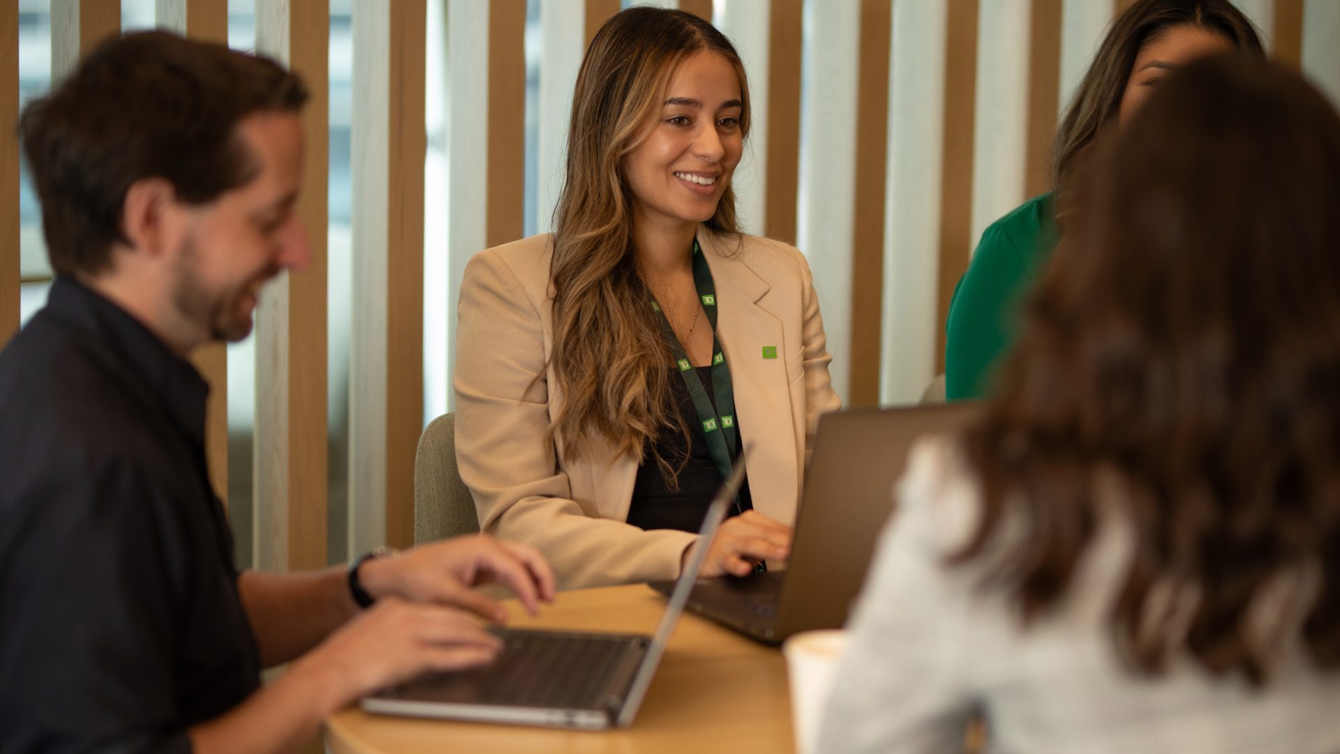 Un groupe de collègues est réuni autour d’une table de conférence dans un bureau.