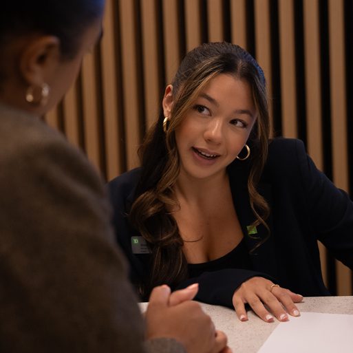 A man signs paperwork for a loan at an auto dealership.