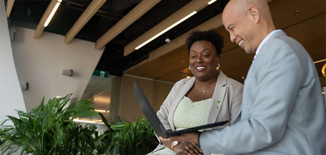 Colleagues have a meeting at a conference table covered in print-outs.