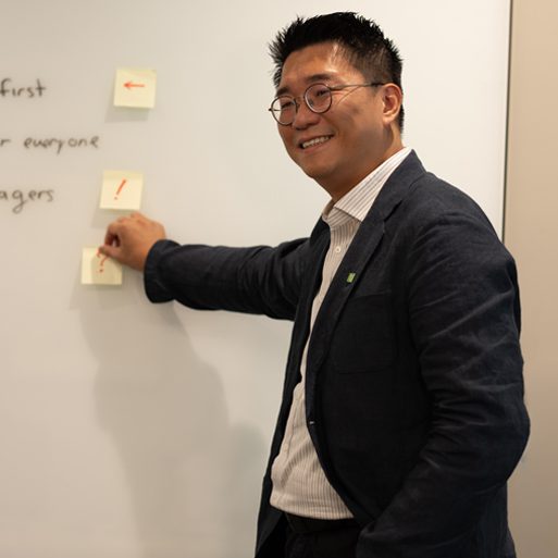 A graphic designer works with a stylus while seated in front of a computer.