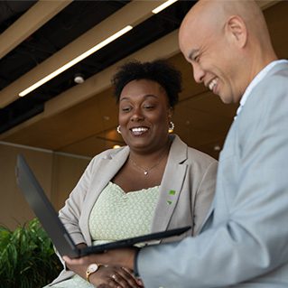 Colleagues have a meeting at a conference table covered in print-outs.