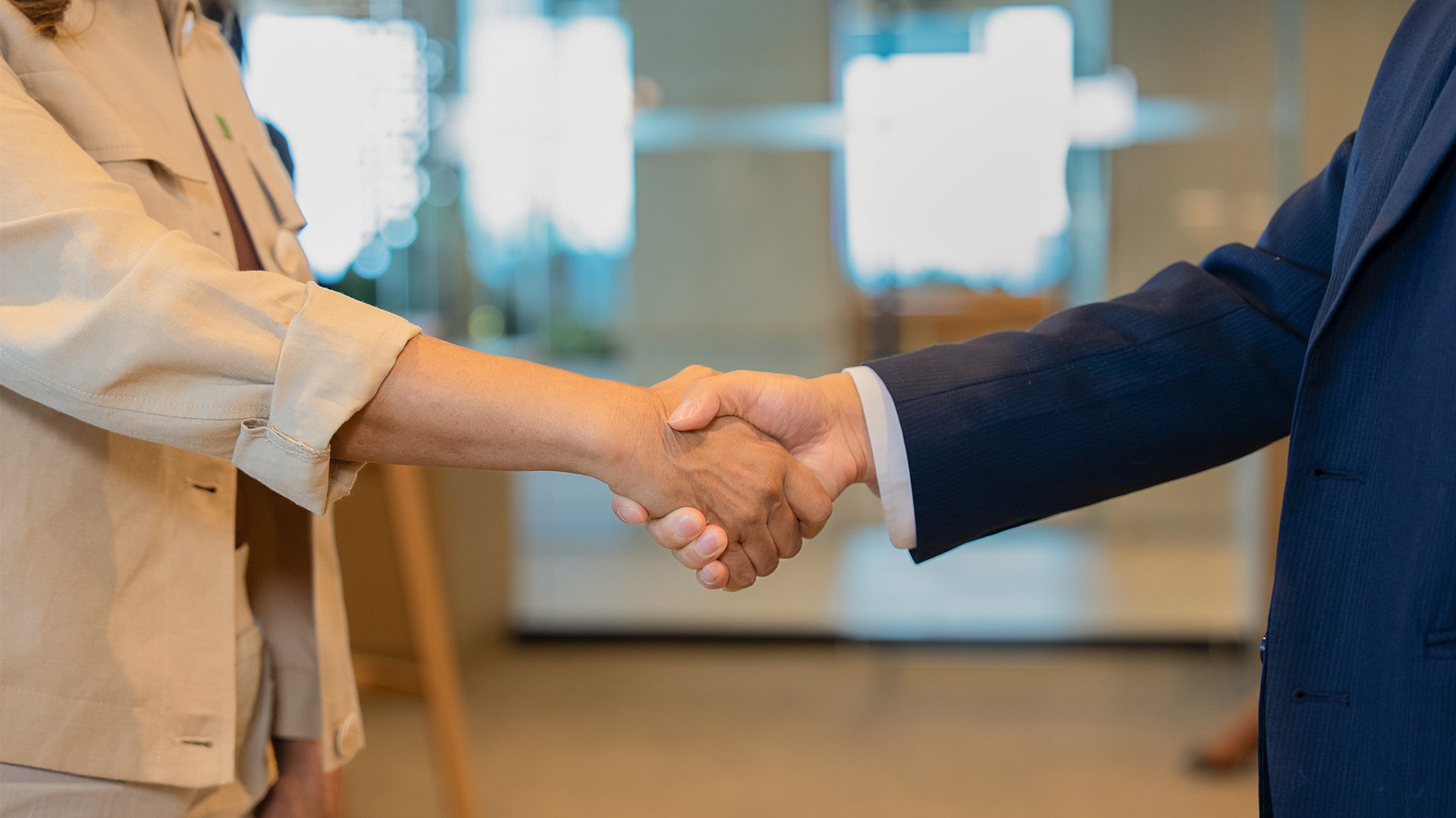 A person smiles while shaking hands with a TD representative.